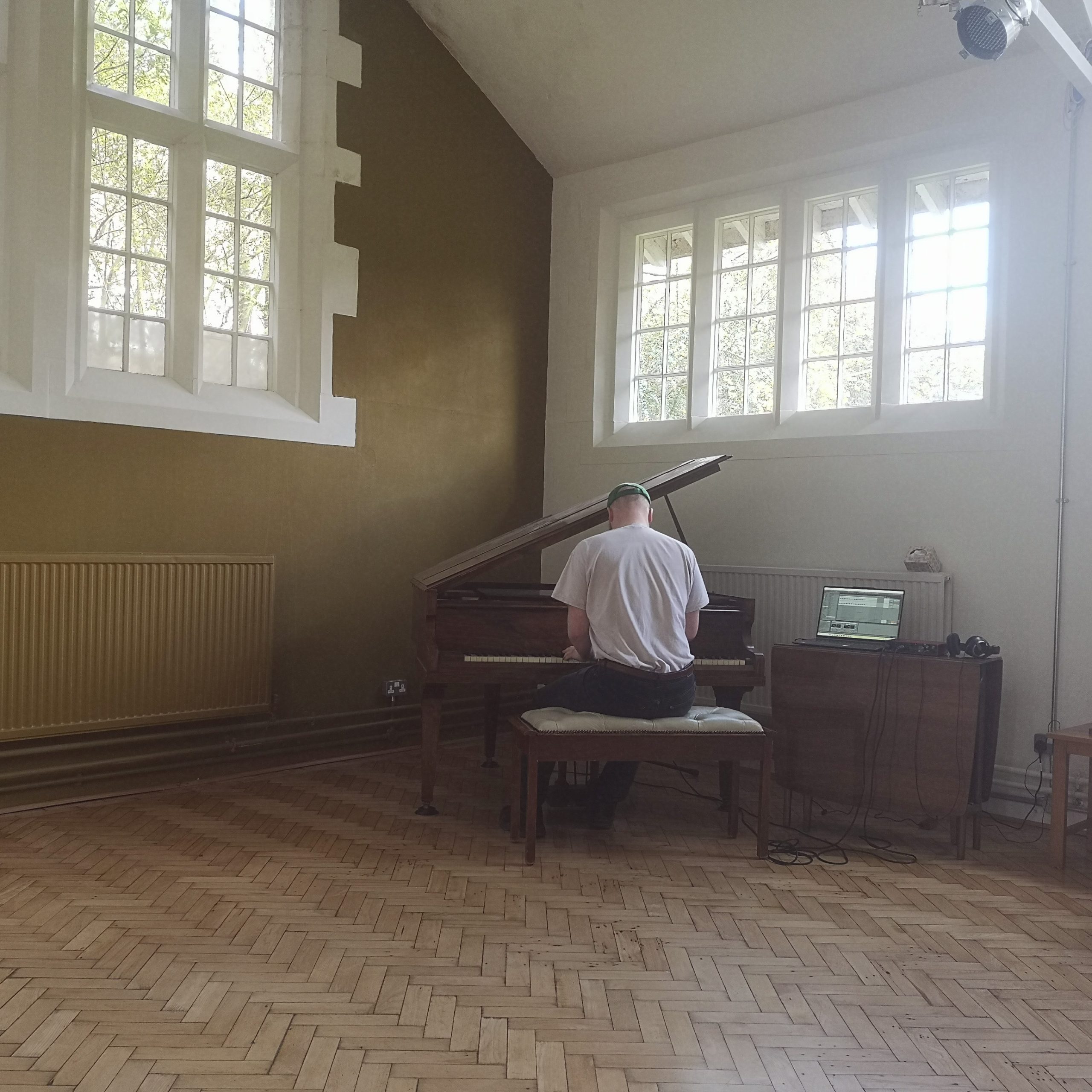 A photo of a woman with shoulder length brown hair wearing a pink jumper.
